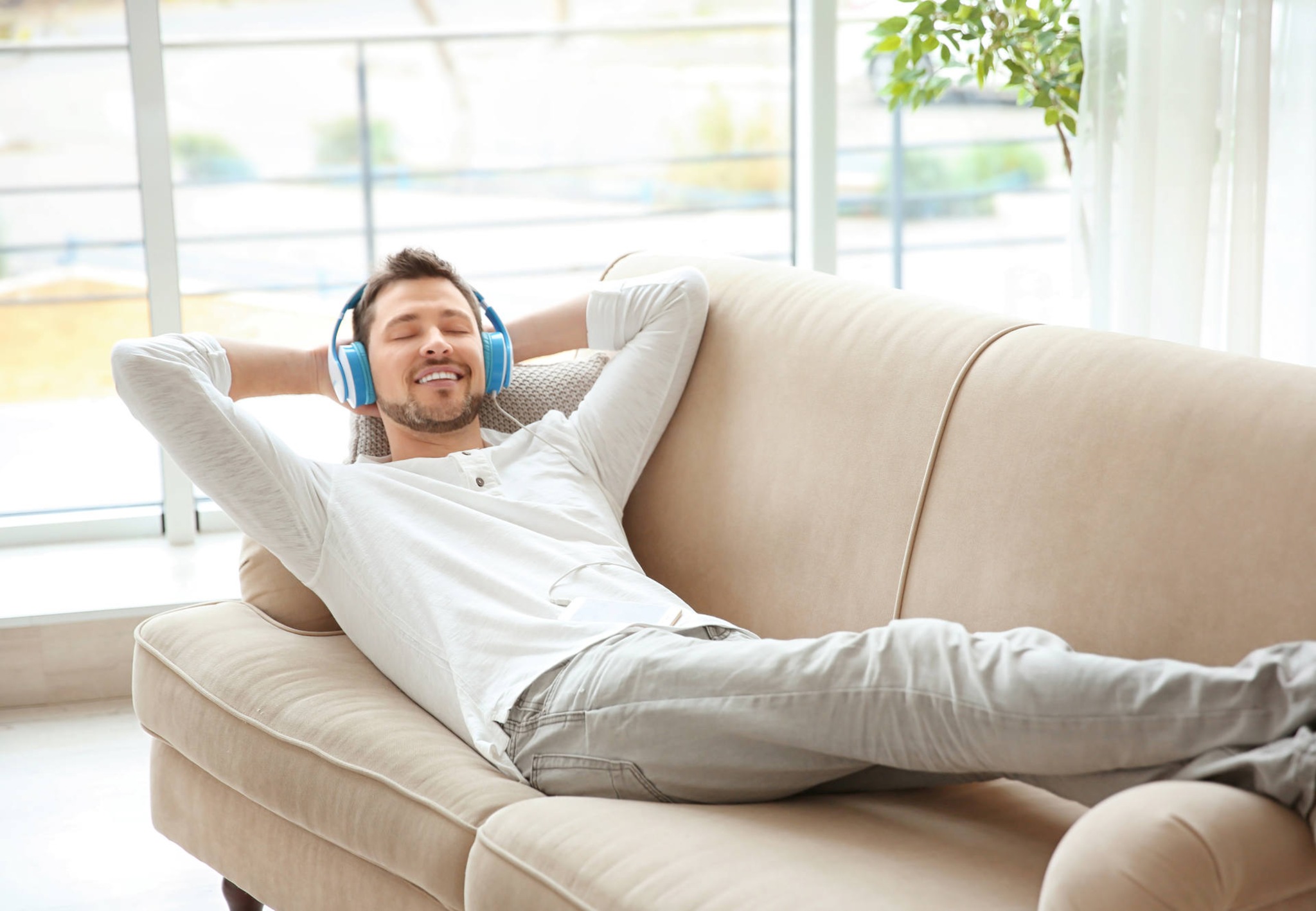 Canzoni per rilassarsi: foto di ragazzo con cuffie sul divano