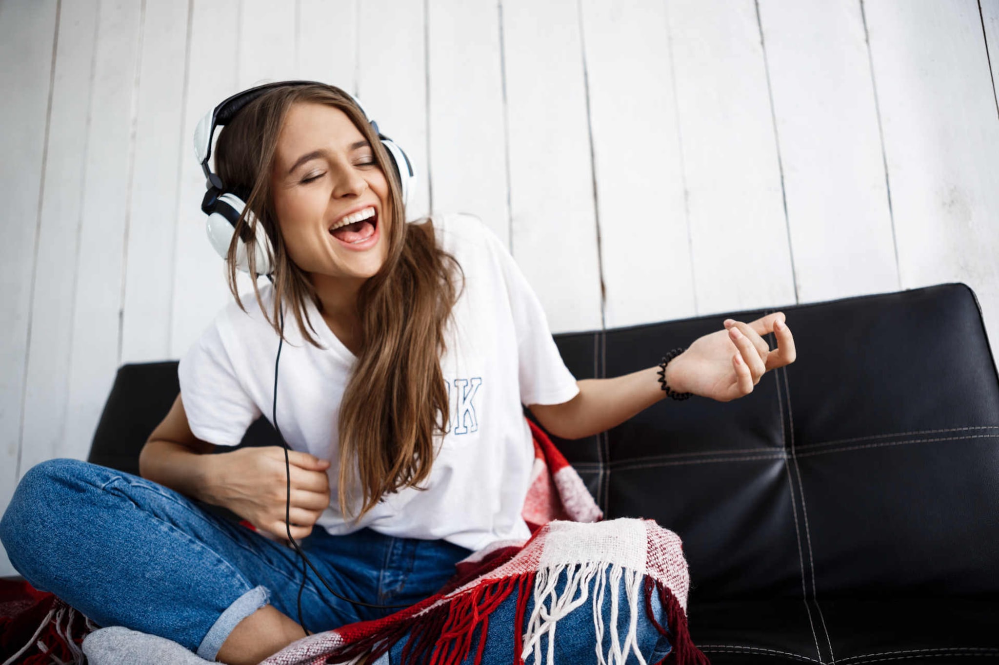 Canzoni allegre: foto di ragazza sorridente che ascolta musica